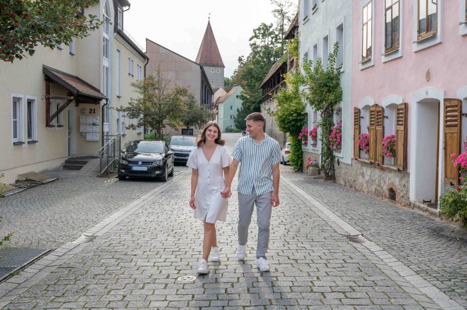 Paarshooting - Paar geht händchen haltend eine Straße entlang