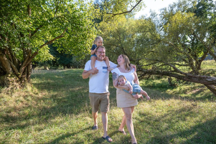 Familienausflug in der Natur mit zwei Kindern und Eltern zwischen Bäumen.